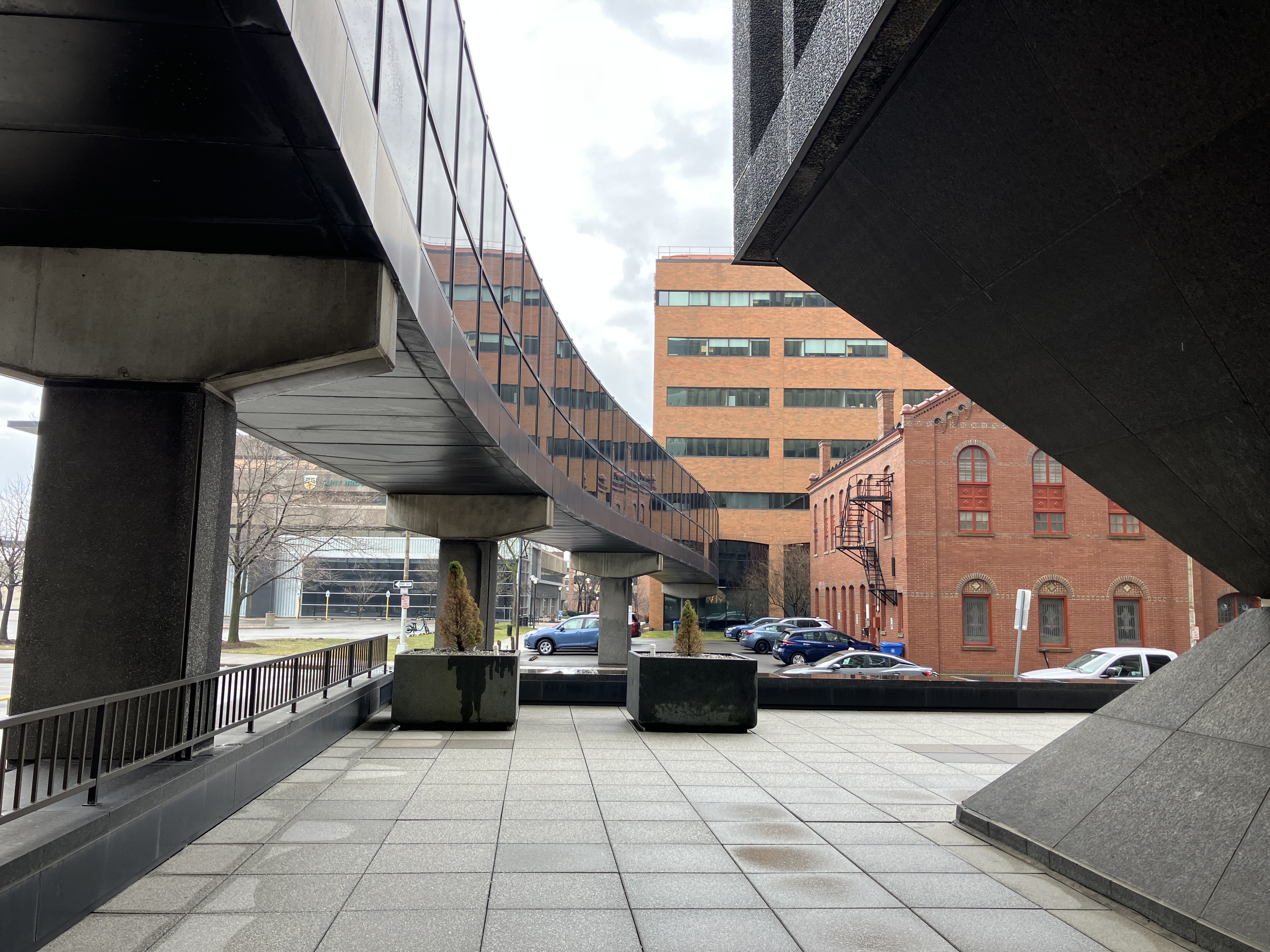 A curvy walkway into a big college building.